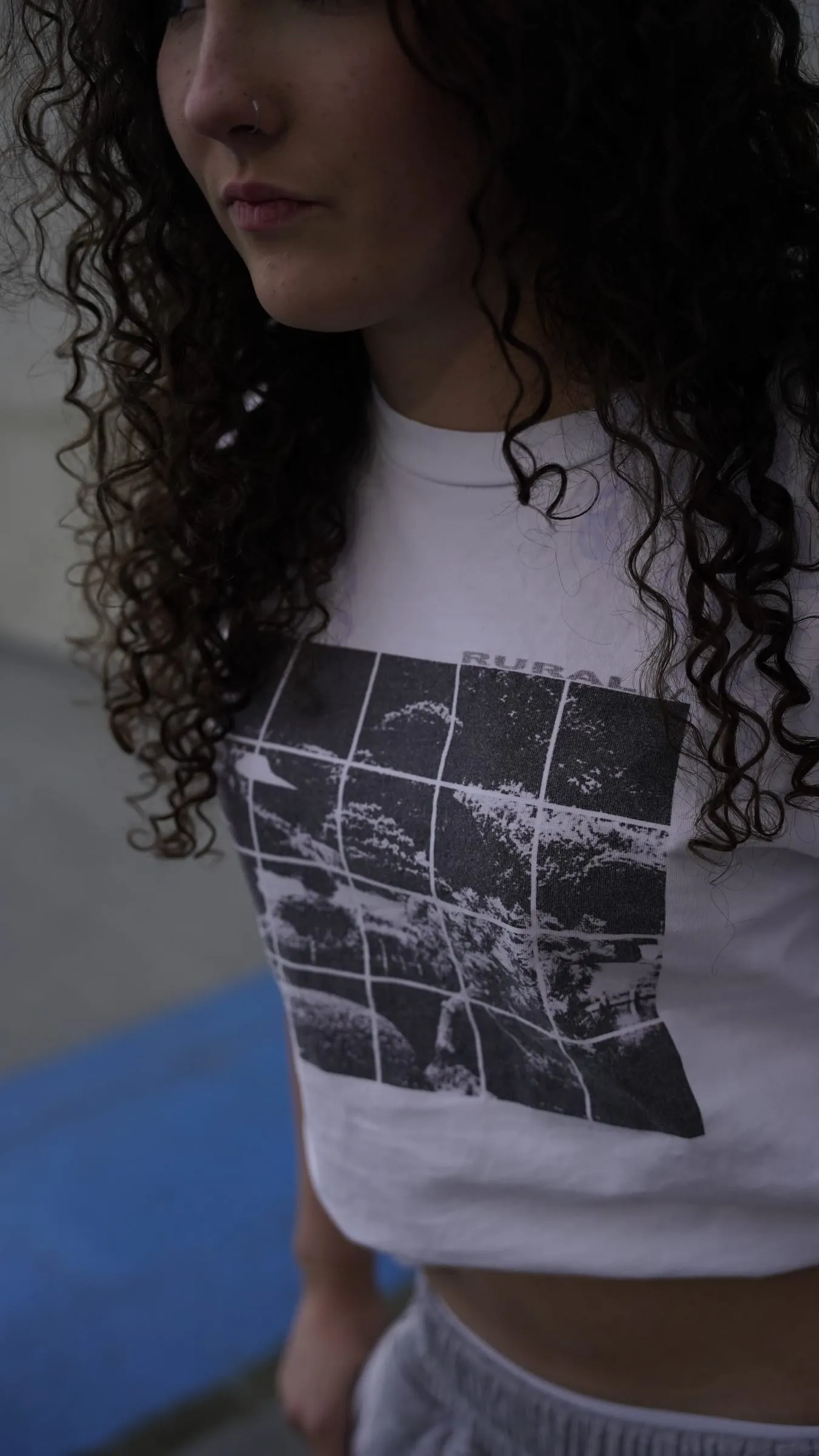 Close on the gridded print, curly hair falling across it.