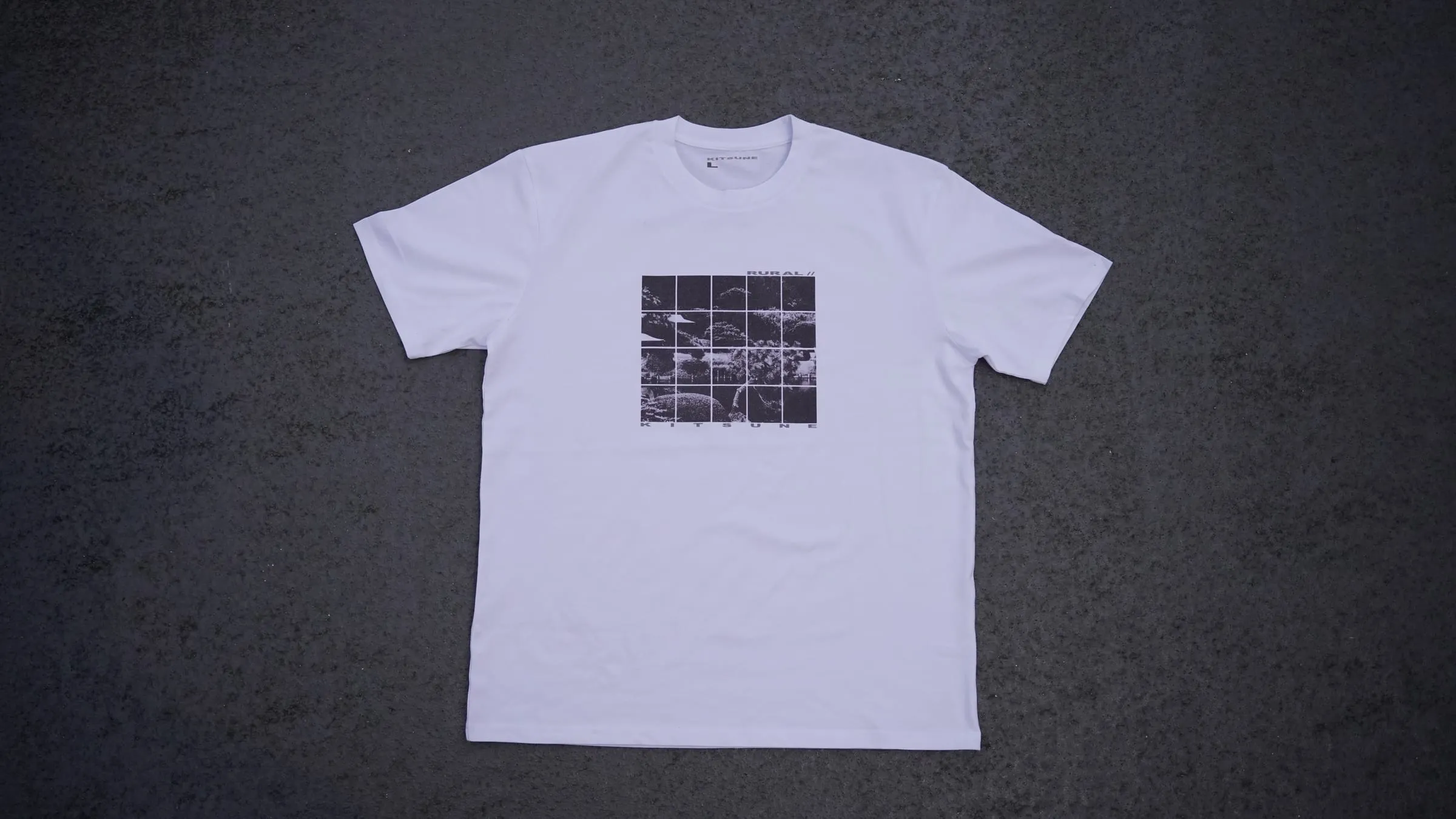 The T-shirt laid flat on dark tarmac.