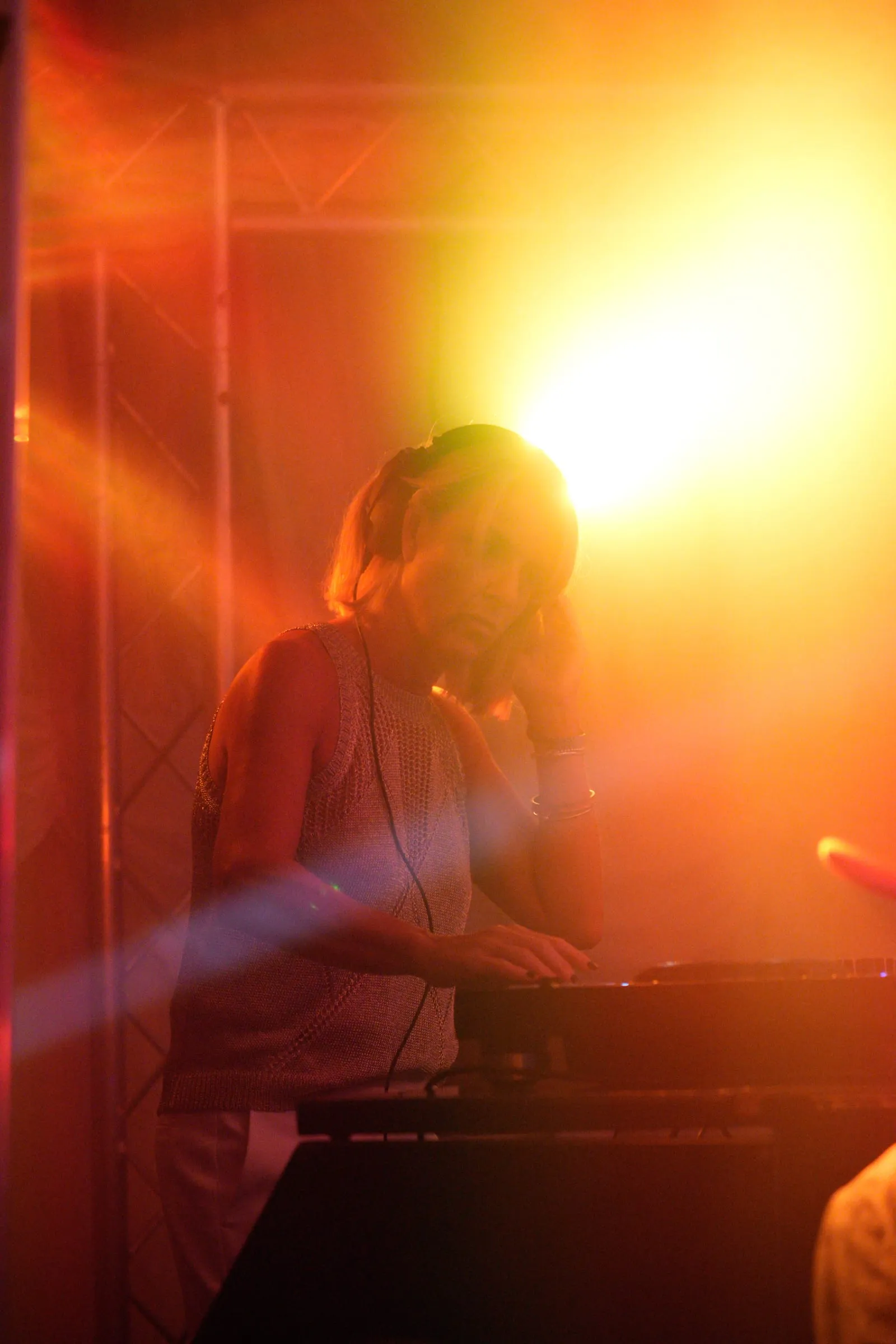 The DJ silhouetted in a flare of yellow light.